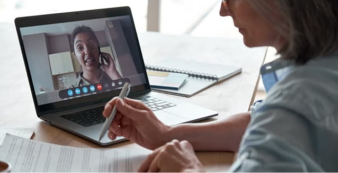 Person participating in online counseling session via laptop video call