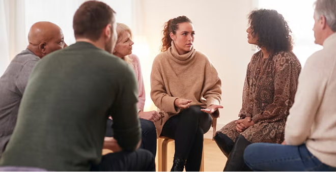 Diverse group seated in circle during support group therapy session