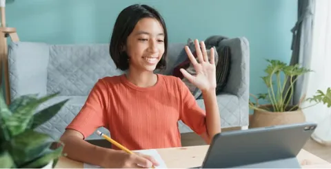 Student waving during online video call