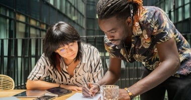 University students writing down their ideas on paper